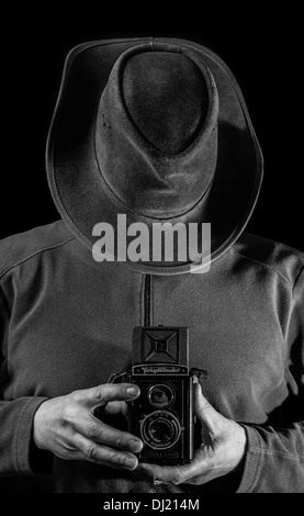 A man holding a vintage camera. Stock Photo