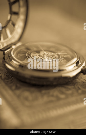 Blurry close up of a antique pocket watch with warm sepia tones. Stock Photo