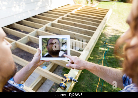 Carpenters Using Digital Tablet At Construction Site Stock Photo