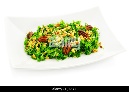 Green fresh salad with roasted nuts. White background. Stock Photo