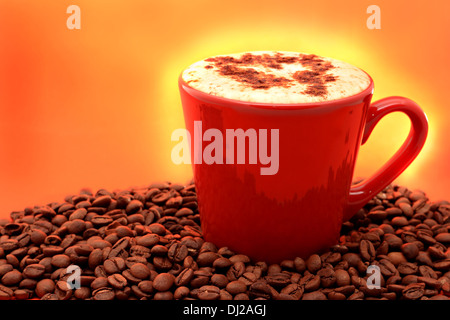 A cup of cappuccino on eye-catching orange backgrounds with fresh coffee beans Stock Photo