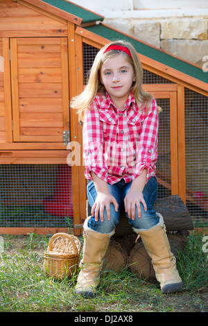 breeder hens kid girl rancher farmer sitting in chicken tractor coop Stock Photo