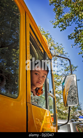 Young, sweet, Bhutanese boy peeping through Bus Window Stock Photo