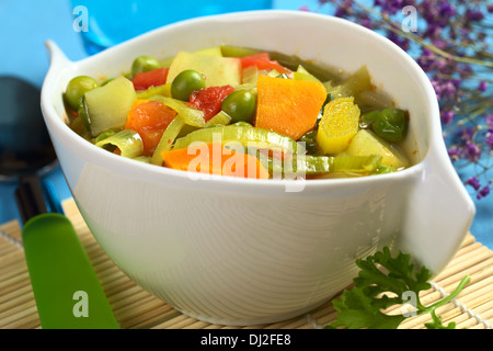 Fresh homemade vegetable soup made of carrot, leek, pea, potato, onion and tomato (Selective Focus) Stock Photo