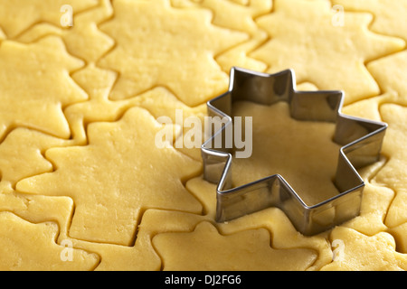Cutting out Christmas cookies from shortcrust dough with a Christmas tree shaped cutter (Selective Focus) Stock Photo