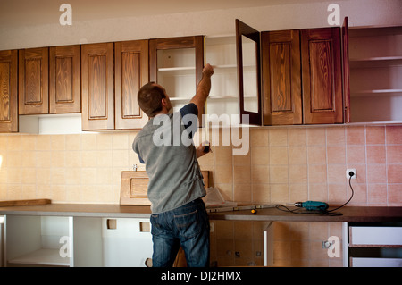 Carpenter working on new kitchen cabinets Stock Photo