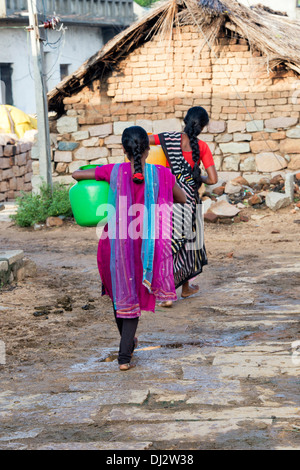Indian teenage girl carrying a water pot in a rural Indian village street. Andhra Pradesh, India Stock Photo