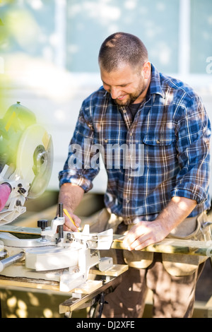 Happy Carpenter Marking On Wood At Table Saw Stock Photo