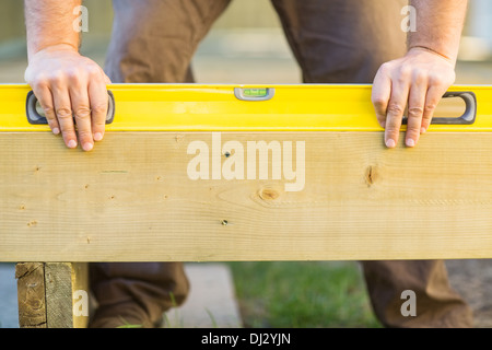 Carpenter's Hands Using Spirit Level On Wood Stock Photo