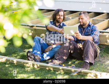 Carpenters Using Digital Tablet At Construction Site Stock Photo