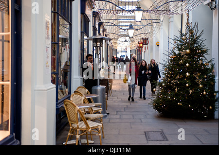 London, UK - November 19, 2013:People stroll in the Royal Opera Arcade, the first covered shopping street in Britain Stock Photo