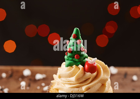 Xmas tree cupcake on white snow flakes Christmas background Stock Photo
