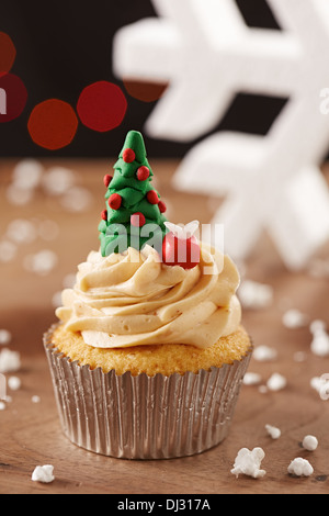 Xmas tree cupcake on white snow flakes Christmas background Stock Photo