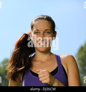 Young woman making sports workout in a park by running or jogging Stock Photo