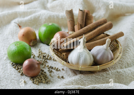 food ingredients on sackcloth ( garlic , onion , lime , peppercorns and cinnamon ) Stock Photo