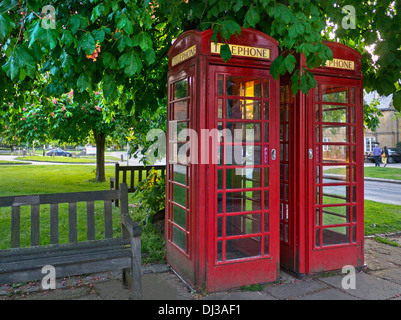 Two traditional red telephone boxes at sunset in Broadway High Street Worcestershire Cotswolds  England Stock Photo