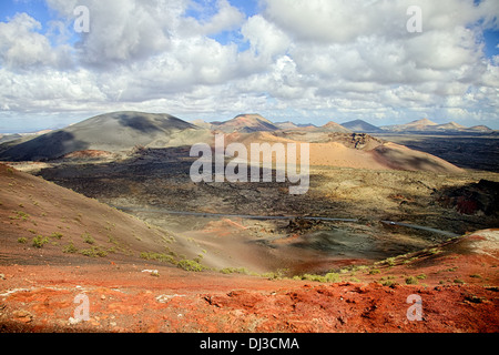 Moon-like landscape and a car driving through it in Timanfaya National Park in Spain Stock Photo