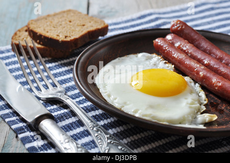 Fried egg with sausages on plate over wooden background Stock Photo