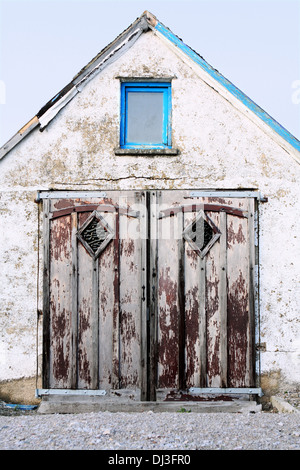 Doors and a window on the front  of an old unused building Stock Photo