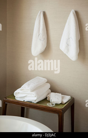 Folded and hanging white towels in bathroom Stock Photo