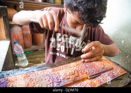 Young boy hammering traditional crafts in Kathmandu, Nepal Stock Photo