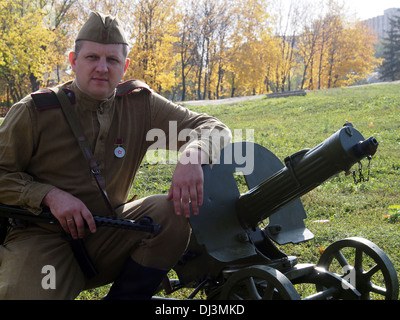 re-enactor in the form of a Red Army soldier with a machine gun Maxim Stock Photo