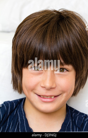 Head and shoulder portrait of a Caucasian male child, boy 10 - 12 year old, face facing viewer, big smile on his face. Eye-contact. Stock Photo