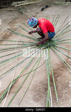 Indian man weaving a traditional goat pen from bamboo in a rural Indian village. Andhra Pradesh, India Stock Photo