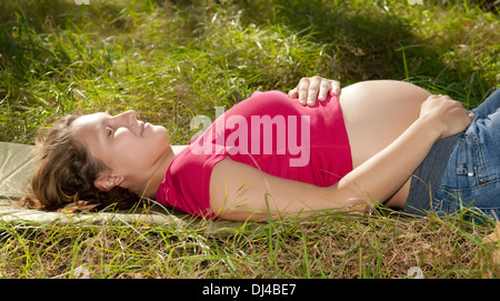 pregnant young woman relaxing on a meadow Stock Photo
