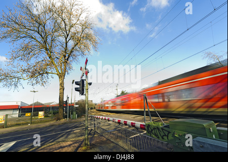 a passenger train passing a level crossing Stock Photo