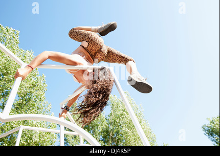 Woman Playing On Jungle Gym, Climbing It And Spinning Over The Bars; California, United States Of America Stock Photo