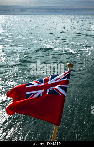 Red ensign flies on the stern of a yacht crossing the English Channel Stock Photo