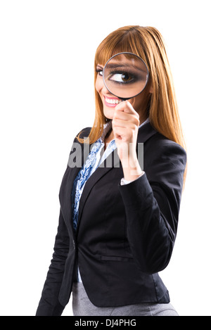 Businesswoman looking through magnifying glass Stock Photo