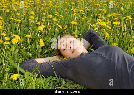 young woman lies on a flower meadow Stock Photo