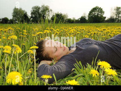 young woman lies on a flower meadow Stock Photo