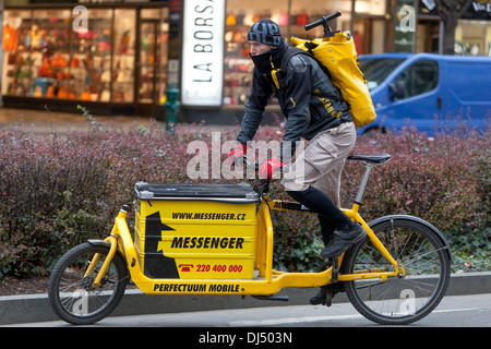 Male courier with bicycle delivering packages in city Prague, Czech Republic, Europe delivery man and bike Stock Photo