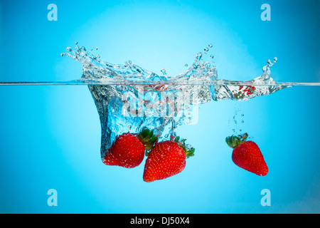 Fresh strawberries splashing in water Stock Photo