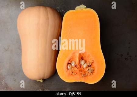 Butternut Squash on a metal cooking sheet. The fruit is cut in half showing both the inside and outside. Horizontal format. Stock Photo