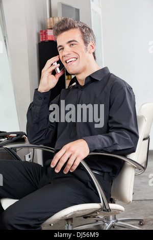 Mature Man Using Cellphone At Salon Stock Photo