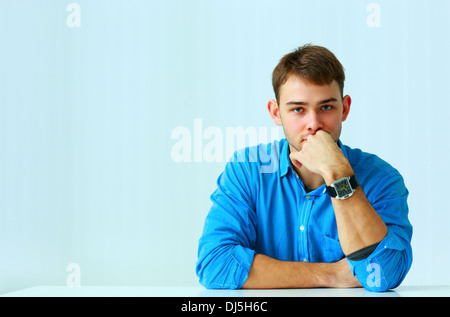 Portait of a young thoughtful businessman in blue shirt at office Stock Photo