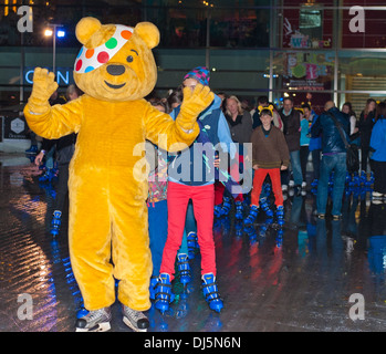 Pudsey Bear at London's Canary Wharf Leading a successful attempt of the longest conga on ice, 353 people, for Children In Need. Stock Photo