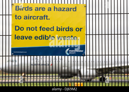 Signs about bird strikes on security fencing at Manchester Airport, UK. Stock Photo