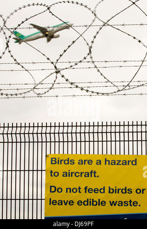 Signs about bird strikes on security fencing at Manchester Airport, UK. Stock Photo