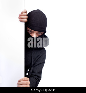 Robber hiding behind a empty white  space for text Stock Photo