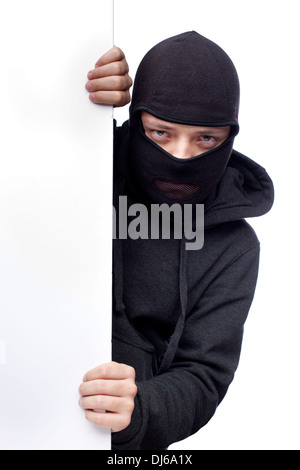 Robber hiding behind a empty white  space for text Stock Photo