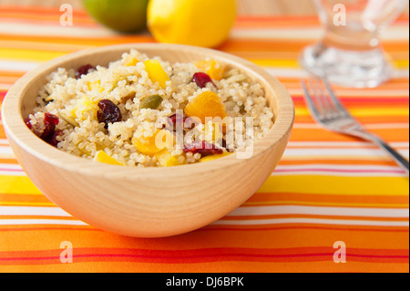 Colorful fruit and quinoa salad with pumpkin seeds on a colorful table cloth Stock Photo