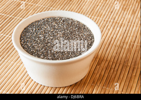 Beige dish of chia seeds on a bamboo mat Stock Photo