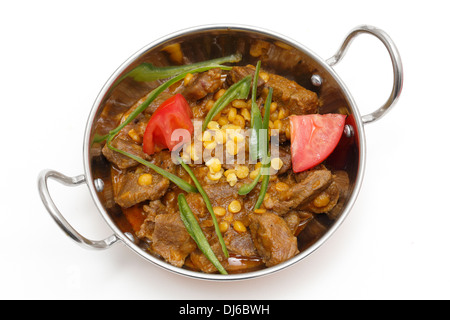 Lahore-style lamb and Chana dhal (split pea) curry, garnished with sliced chillies and chopped tomato, in a kadai serving bow. Stock Photo