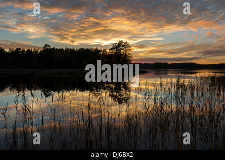 Beautiful sunset reflecting on a lake surface. Stock Photo