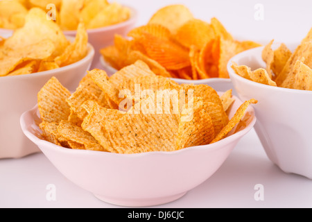 Potato and wheat chips in bowls on gray background. Stock Photo
